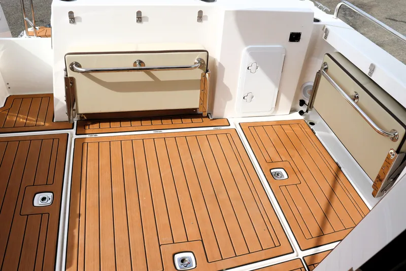 Slide: The Image of 2022 Ranger Tugs R-25 boat deck with teak flooring and foldable seating. - 15