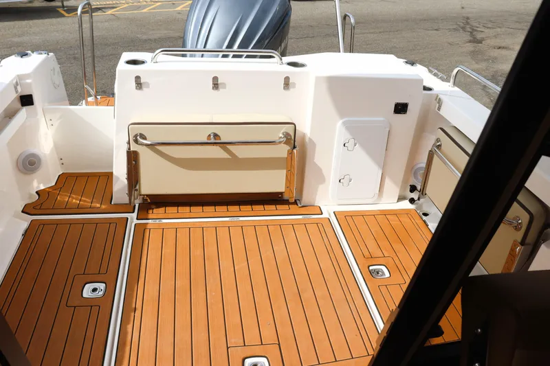 Slide: The Image of 2022 Ranger Tugs R-25 boat deck with teak flooring and storage compartments. - 16