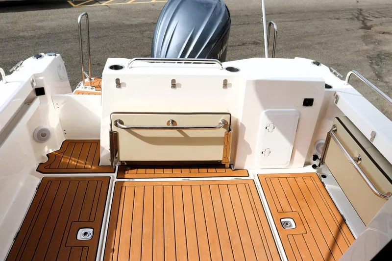 Slide: The Image of 2022 Ranger Tugs R-25 boat deck with teak flooring and storage compartments. - 17