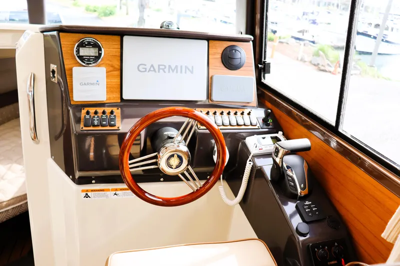 Slide: The Image of 2022 Ranger Tugs R-25 helm with Garmin navigation system and wooden steering wheel. - 21