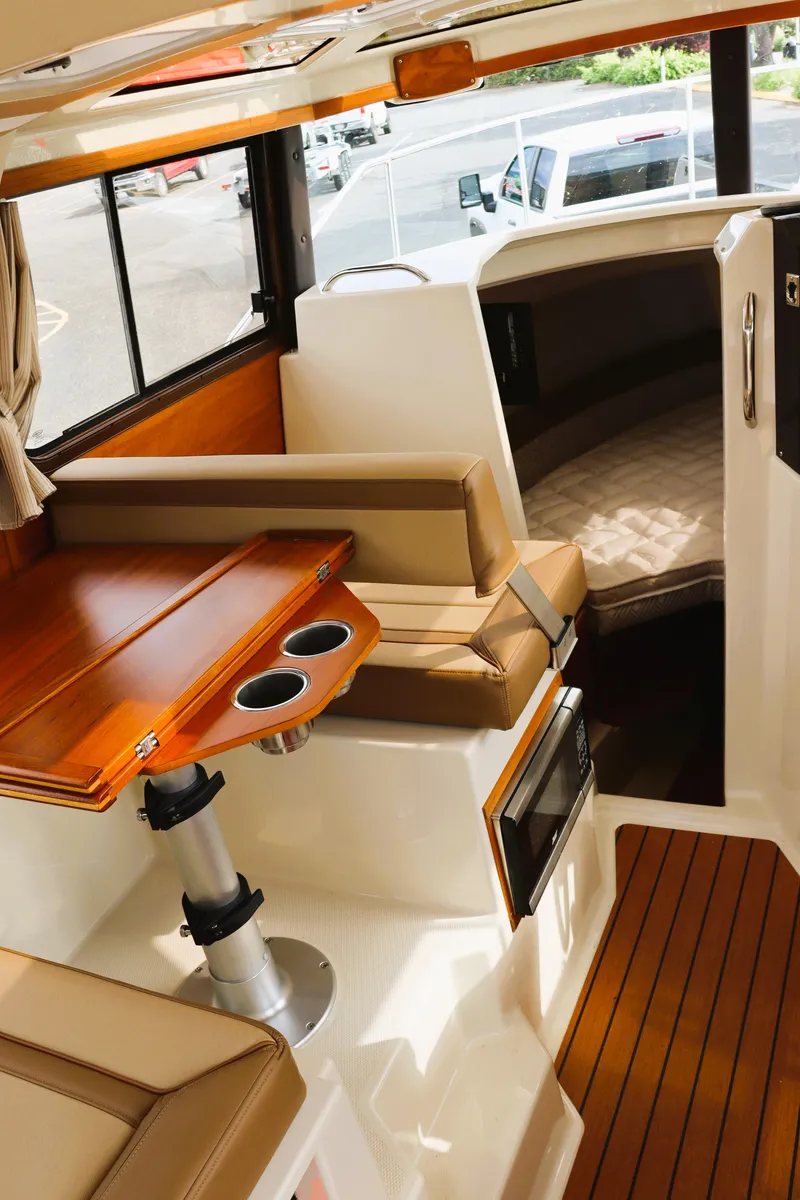 Slide: The Image of 2022 Ranger Tugs R-25 interior with wood accents and seating area. - 22