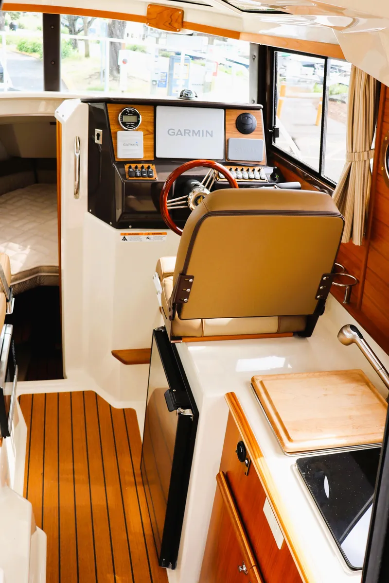 Slide: The Image of 2022 Ranger Tugs R-25 interior with helm, Garmin display, and kitchenette. - 24