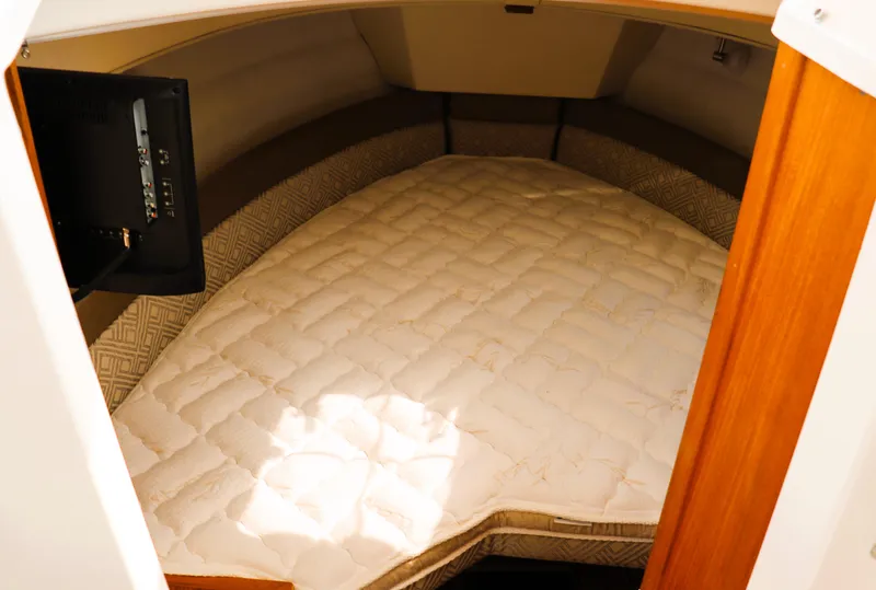 Slide: The Image of 2022 Ranger Tugs R-25 cabin interior with cozy bed and TV. - 26