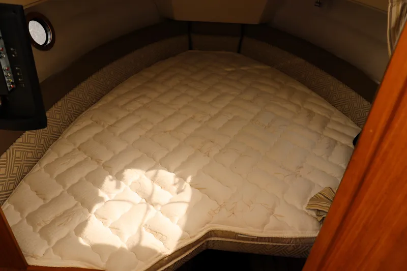 Slide: The Image of 2022 Ranger Tugs R-25 cabin interior with a cozy, quilted bed. - 27
