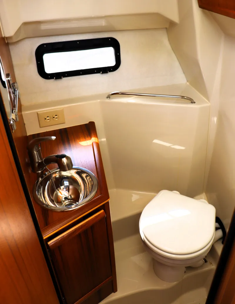 Slide: The Image of 2022 Ranger Tugs R-25 boat bathroom with sink, toilet, and window. - 28