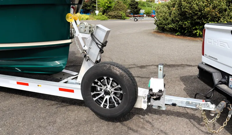 Slide: The Image of Trailer hitching a 2022 Ranger Tugs R-25 boat to a truck in a parking lot. - 8