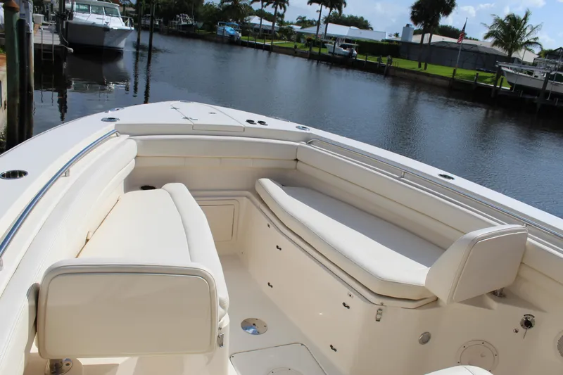 Slide: The Image of 2018 Grady-White Canyon 306 boat interior with seating, docked by a calm waterfront. - 10