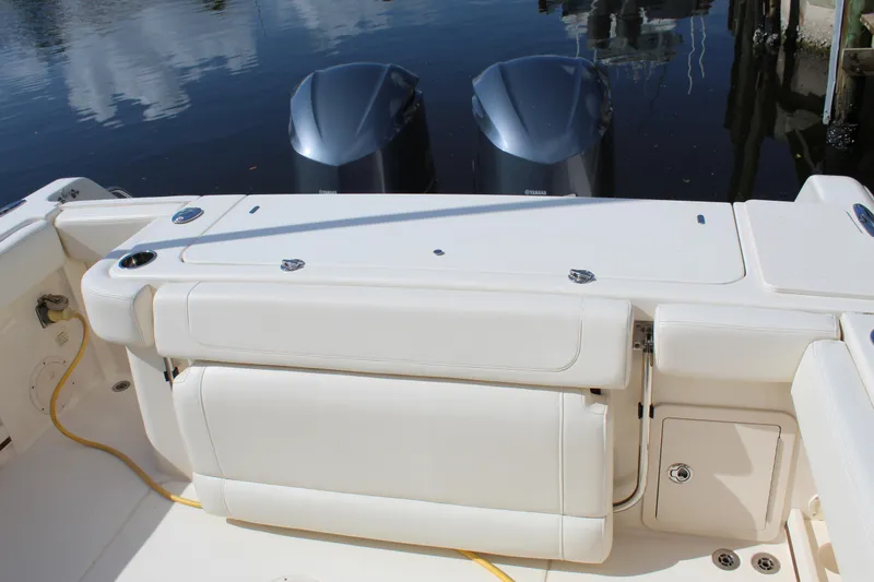 Slide: The Image of 2018 Grady-White Canyon 306 boat with dual outboard motors, docked on calm water. - 16