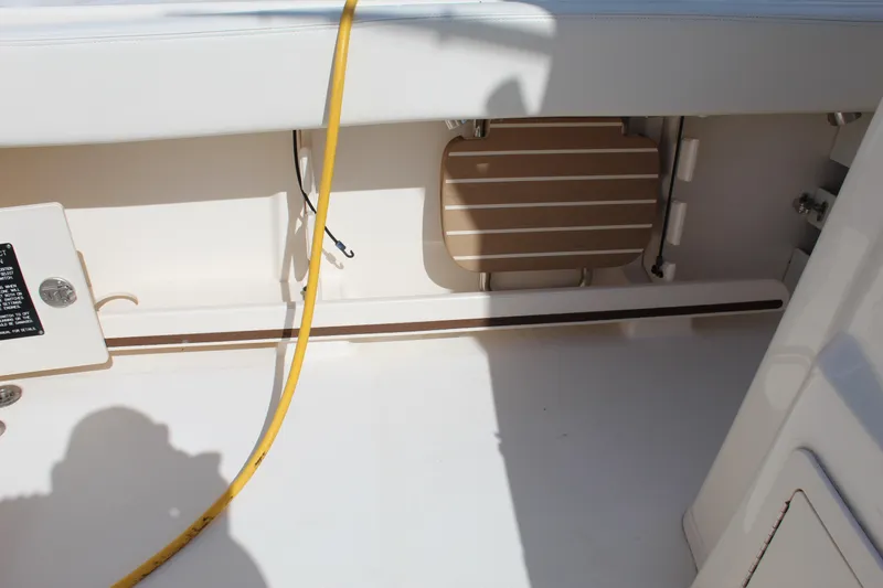 Slide: The Image of 2018 Grady-White Canyon 306 boat interior with storage compartment and yellow cable. - 26