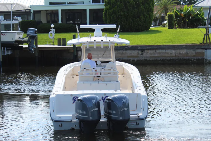 Slide: The Image of 2018 Grady-White Canyon 306 boat with twin Yamaha 300 engines on a calm waterway. - 3