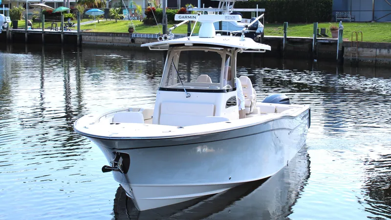 Slide: The Image of 2018 Grady-White Canyon 306 boat on calm water near a dock. - 4