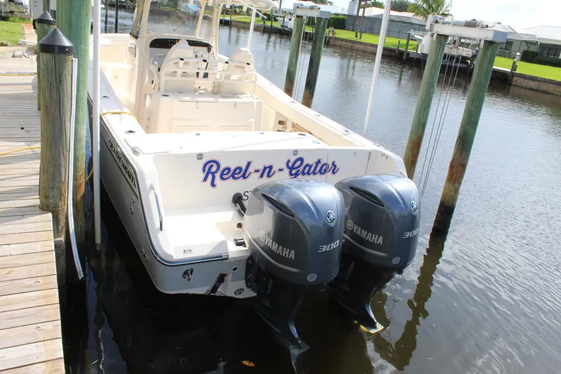 Slide: The Image of 2018 Grady-White Canyon 306 boat with twin Yamaha 300 engines docked in a marina. - 5