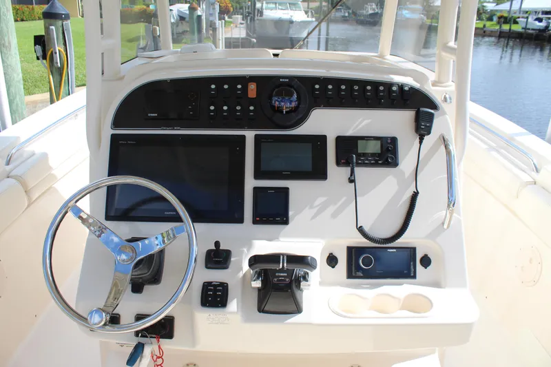 Slide: The Image of 2018 Grady-White Canyon 306 helm with steering wheel, navigation screens, and control panel. - 8
