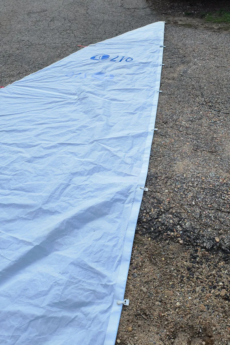 Slide: The Image of White sail for Hunter 216 boat, 2008 model, laid on gravel surface. - 13