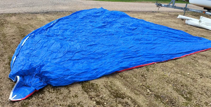 Slide: The Image of Blue sail from a 2008 Hunter 216 boat laid out on the ground. - 19