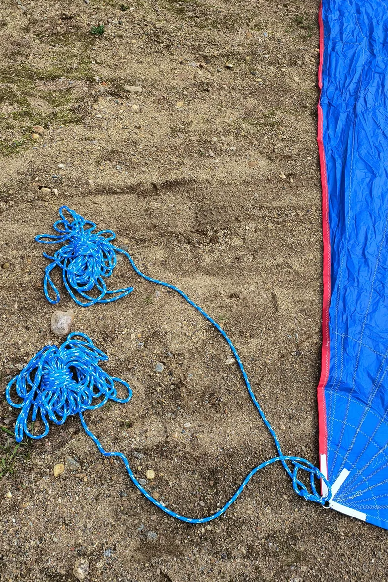 Slide: The Image of Blue parachute ropes on ground, next to a red and blue parachute canopy. Hunter 216, 2008. - 20