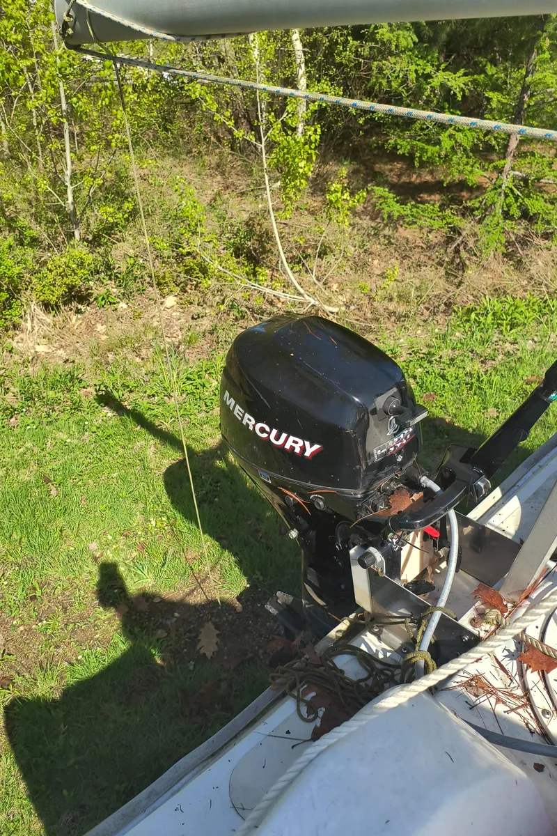 Slide: The Image of Hunter 216 sailboat with Mercury outboard motor, 2008 model, on grassy terrain. - 22