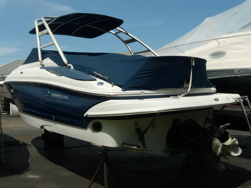 Slide: The Image of 2006 Crownline 260 LS boat with blue cover and canopy, docked outdoors. - 4