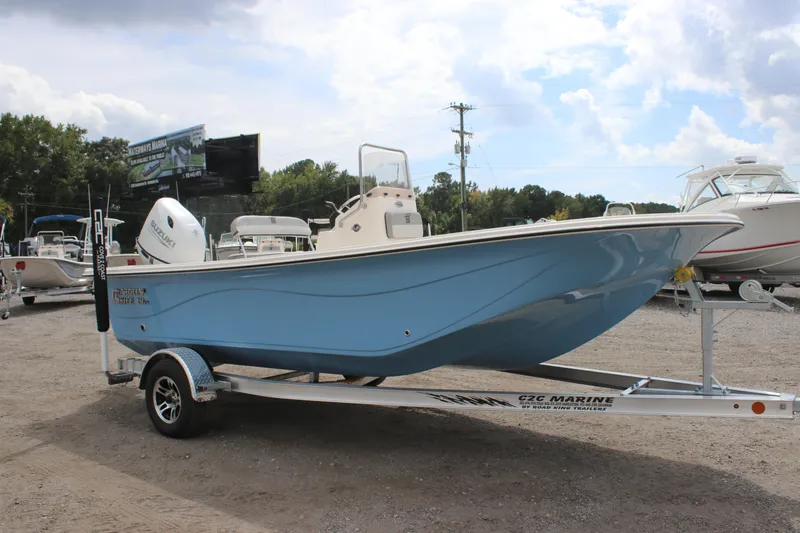 The Image of 2025 Carolina Skiff 19 LS boat on trailer, blue hull, parked outdoors. - 1