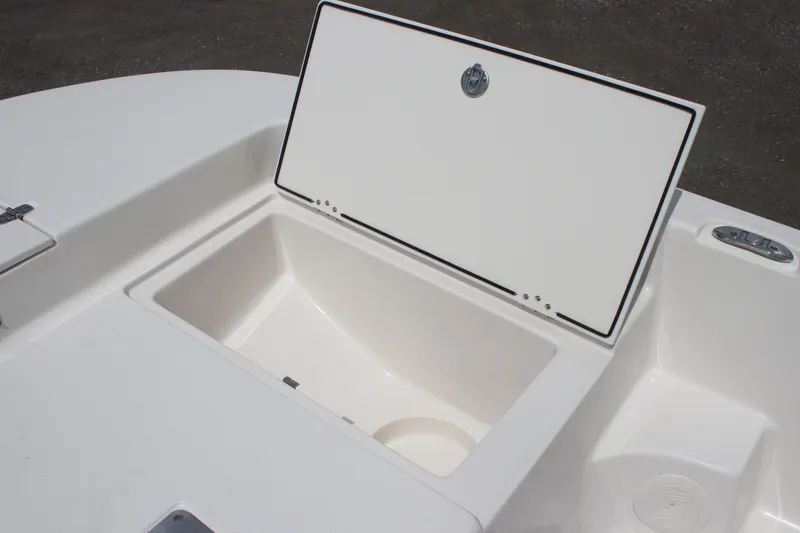 Slide: The Image of 2025 Carolina Skiff 19 LS boat storage compartment, open lid, white interior. - 10