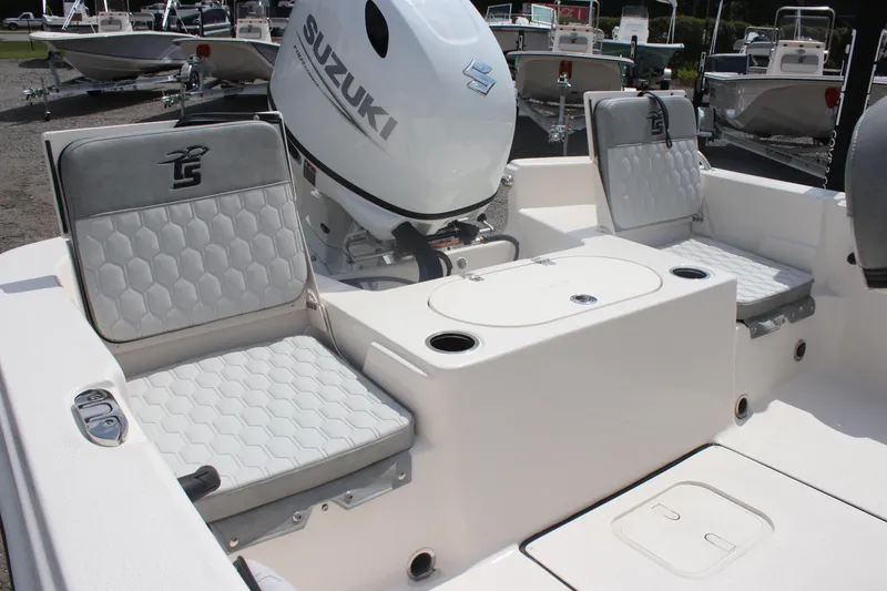 Slide: The Image of 2025 Carolina Skiff 19 LS boat interior with Suzuki engine, featuring cushioned seating and storage compartments. - 18