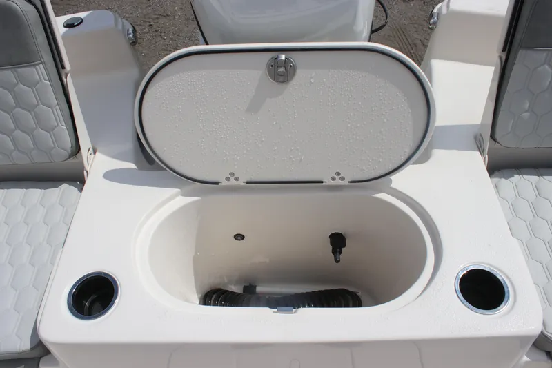 Slide: The Image of 2025 Carolina Skiff 19 LS boat interior with open storage compartment and cup holders. - 19