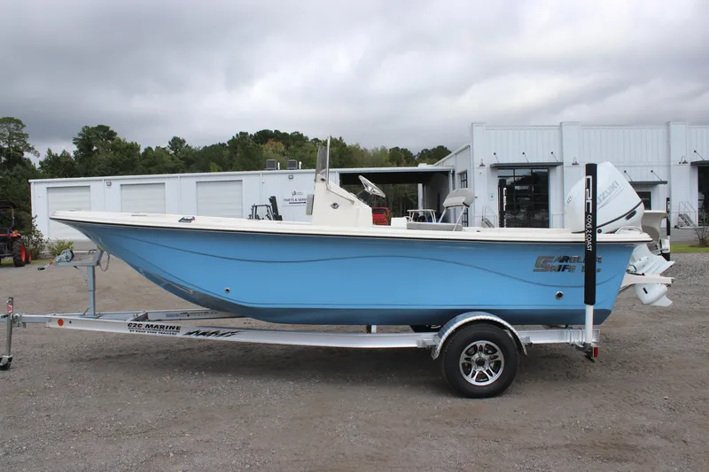 Slide: The Image of 2025 Carolina Skiff 19 LS boat on trailer, blue hull, parked outdoors. - 3