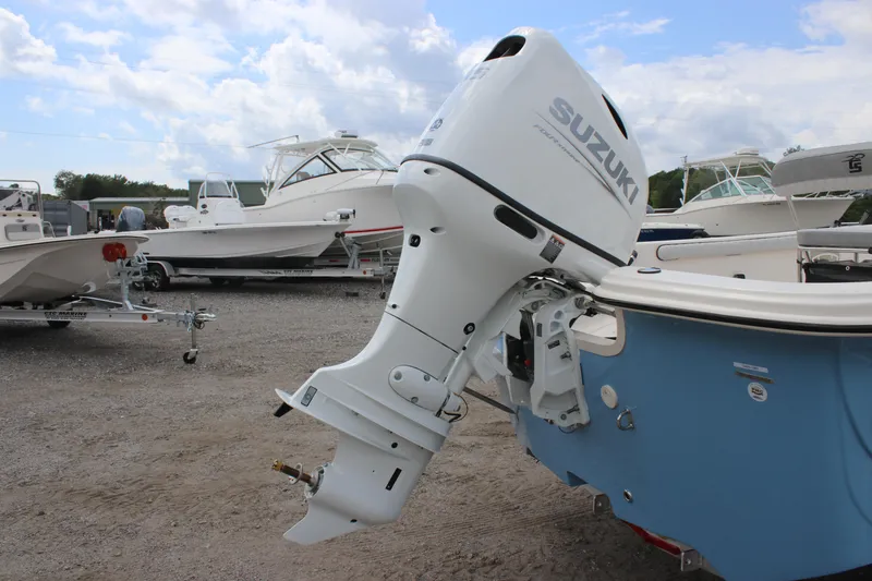 Slide: The Image of 2025 Carolina Skiff 19 LS with Suzuki outboard motor, parked on gravel lot. - 5