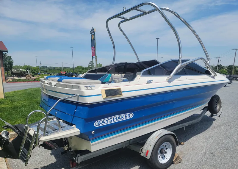 Slide: The Image of 1988 Bayliner 2150 Capri boat on trailer, blue and white design, outdoor setting. - 1