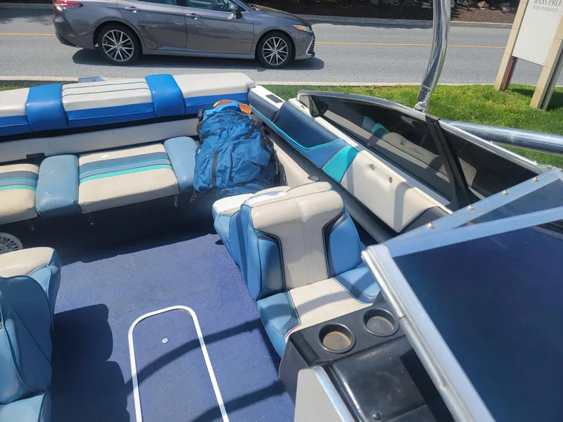 Slide: The Image of 1988 Bayliner 2150 Capri boat interior with blue and white seating, parked near a road. - 10