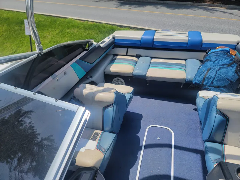 Slide: The Image of 1988 Bayliner 2150 Capri boat interior with blue and white seating, parked near a road. - 11