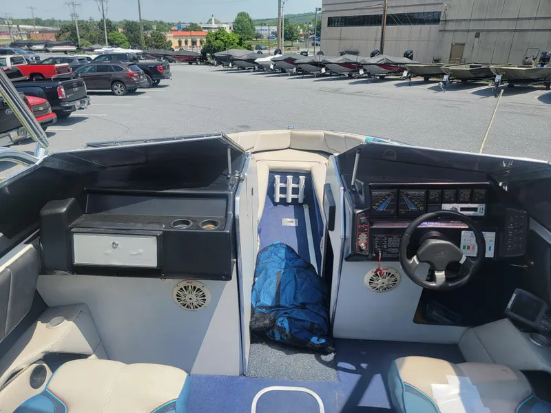 Slide: The Image of 1988 Bayliner 2150 Capri boat interior with steering wheel and seating, parked in a lot. - 14