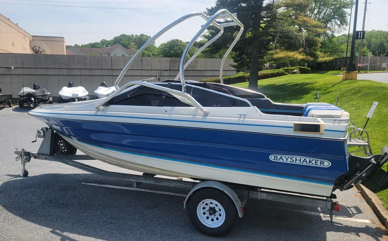 Slide: The Image of 1988 Bayliner 2150 Capri boat on trailer, blue and white design, parked outdoors. - 2