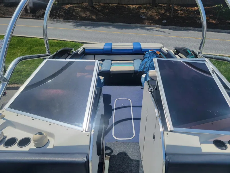 Slide: The Image of 1988 Bayliner 2150 Capri boat interior with blue seating and open deck layout. - 9