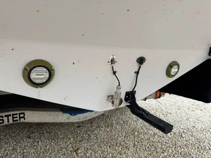 Slide: The Image of 2006 Donzi 32 ZF boat stern with lights and fittings on a gravel surface. - 13