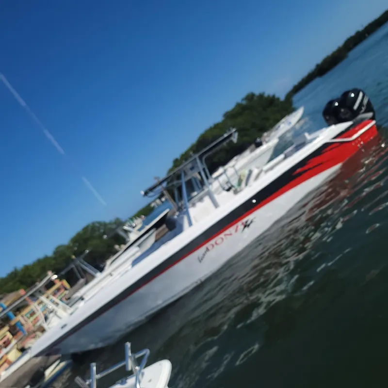 Slide: The Image of 2006 Donzi 32 ZF boat docked on calm water under clear blue sky. - 18