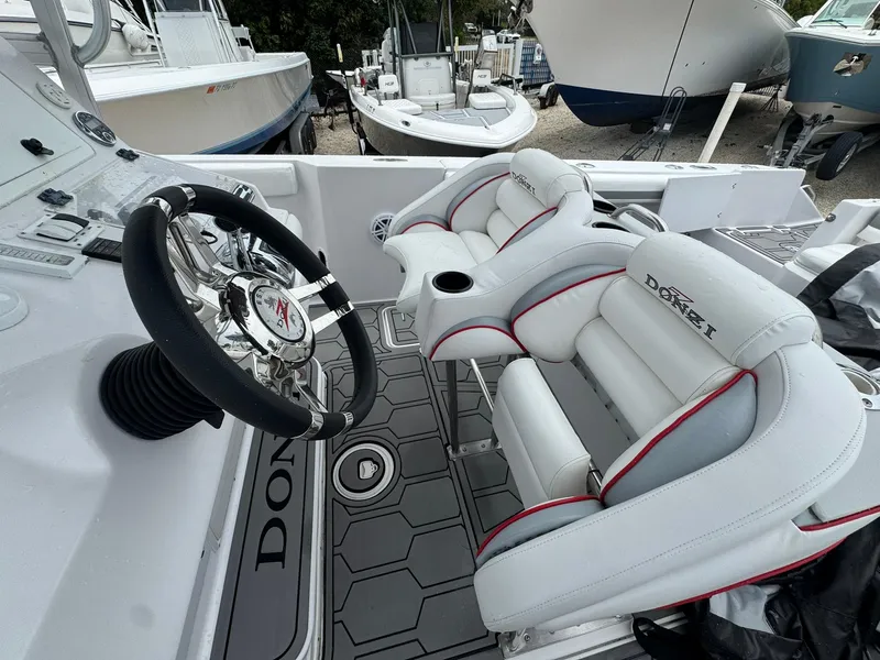 Slide: The Image of 2006 Donzi 32 ZF boat interior with steering wheel and cushioned seats. - 2