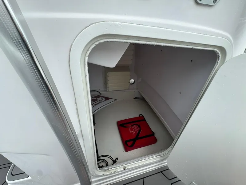Slide: The Image of Storage compartment of a 2006 Donzi 32 ZF boat, featuring a red safety kit. - 8