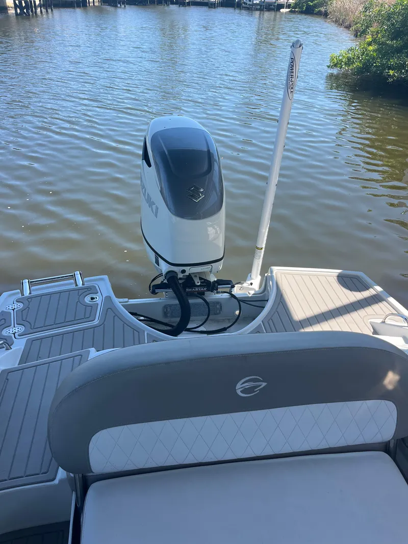 Slide: The Image of 2020 Crownline 280 XSS boat with outboard motor on calm water. - 11