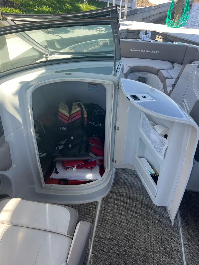 Slide: The Image of 2020 Crownline 280 XSS boat interior with open storage compartment. - 16