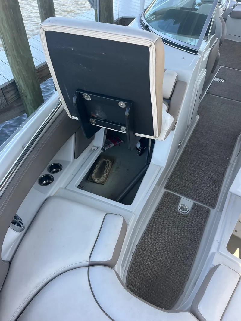 Slide: The Image of 2020 Crownline 280 XSS boat interior with open storage compartment and seating. - 17