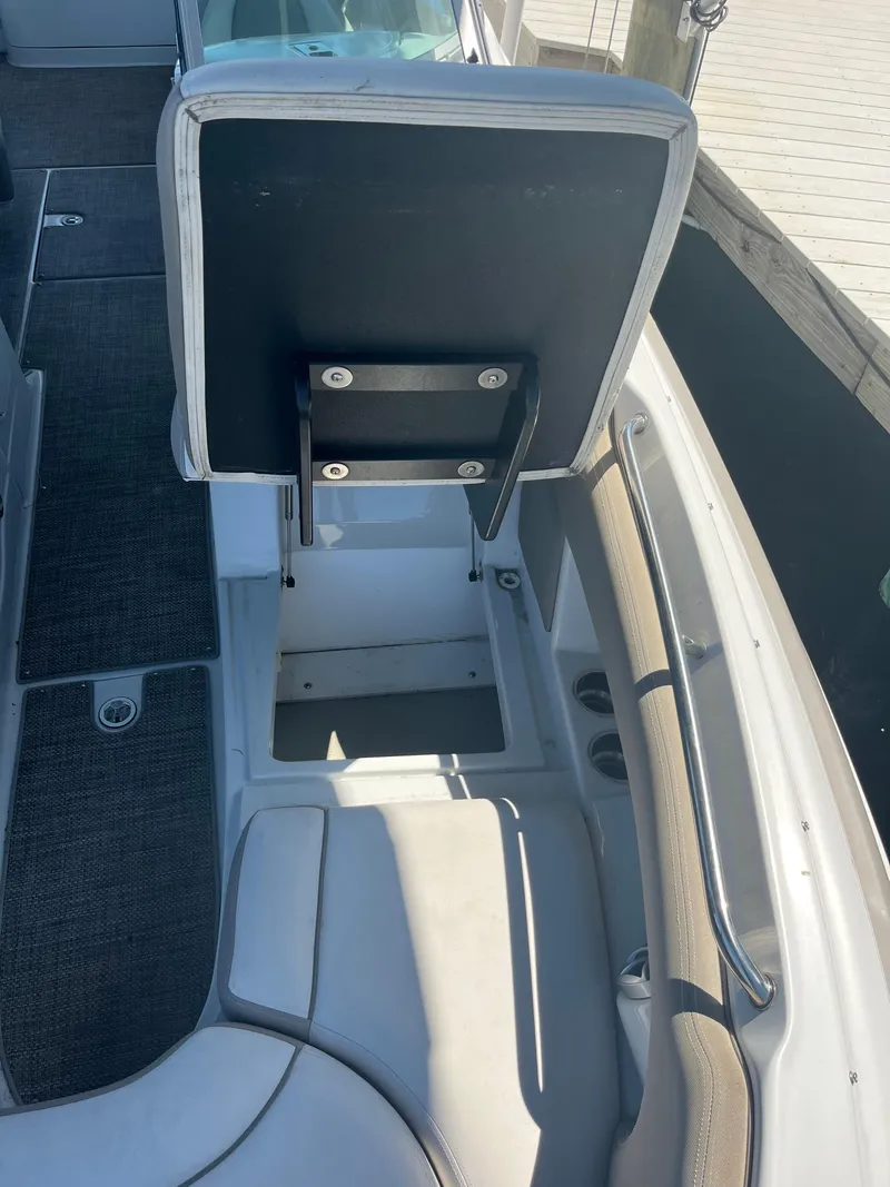 Slide: The Image of 2020 Crownline 280 XSS boat interior with open storage compartment. - 18