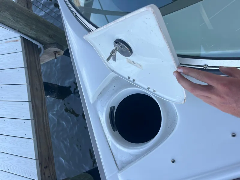 Slide: The Image of 2020 Crownline 280 XSS boat with open storage compartment and key on deck. - 20