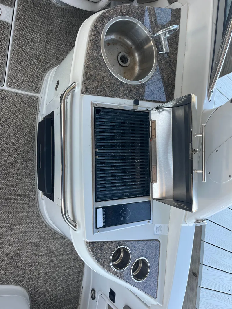 Slide: The Image of 2020 Crownline 280 XSS boat interior with sink and grill station. - 21