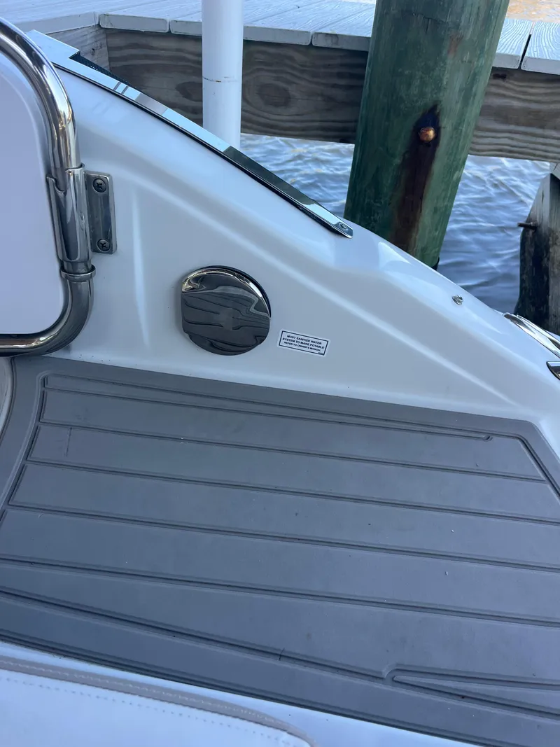 Slide: The Image of 2020 Crownline 280 XSS boat deck with gray flooring near dock. - 32