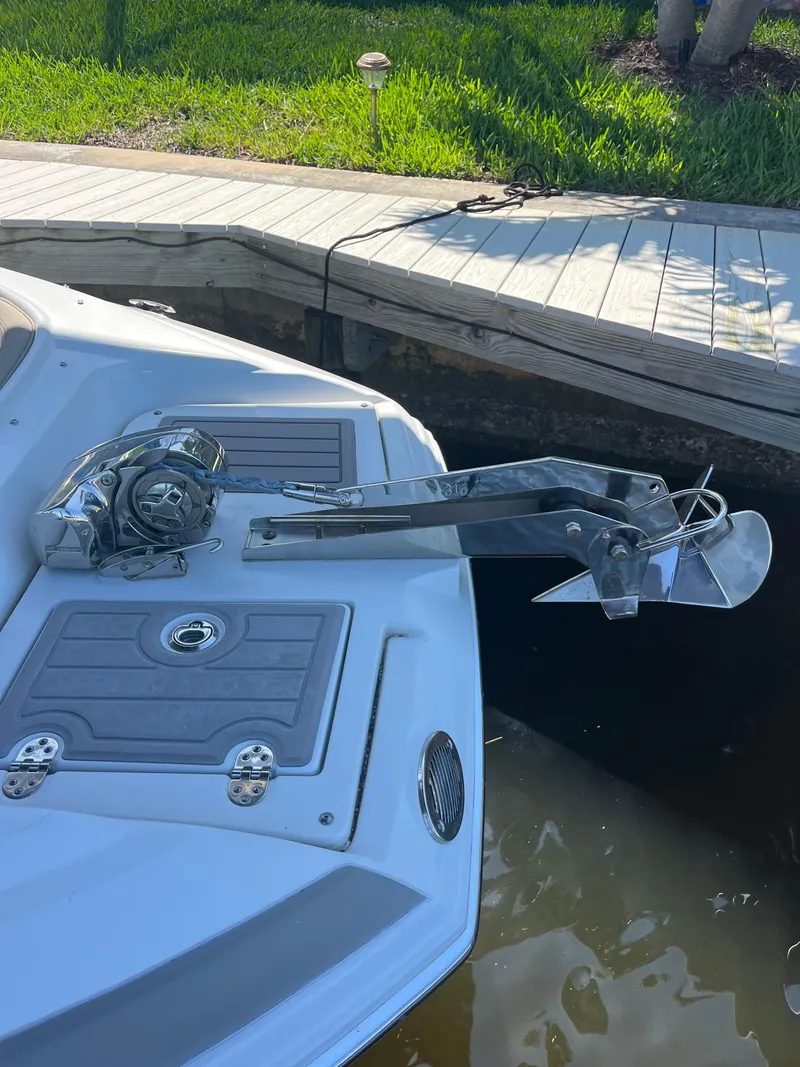 Slide: The Image of 2020 Crownline 280 XSS boat with anchor and winch on deck by dock. - 33