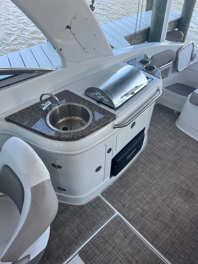 Slide: The Image of 2020 Crownline 280 XSS boat interior with kitchenette, sink, and grill. - 8