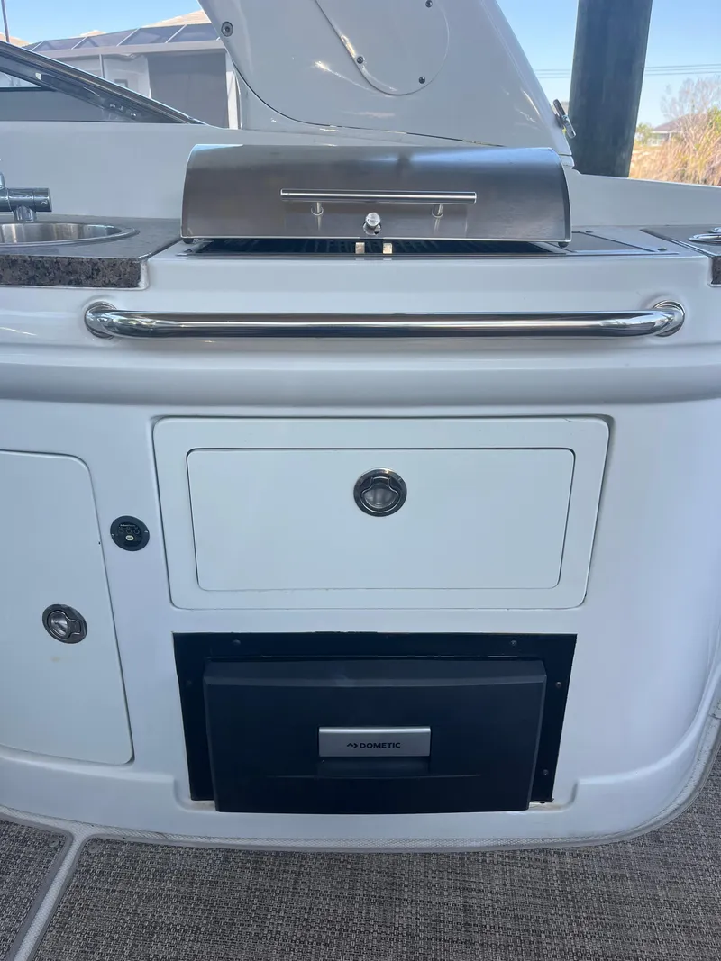 Slide: The Image of 2020 Crownline 280 XSS boat interior with built-in grill and storage compartments. - 9