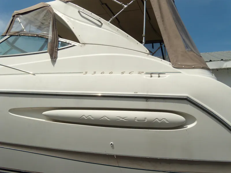 Slide: The Image of 2000 Maxum 3300 SCR boat with beige canopy and sleek design. - 4