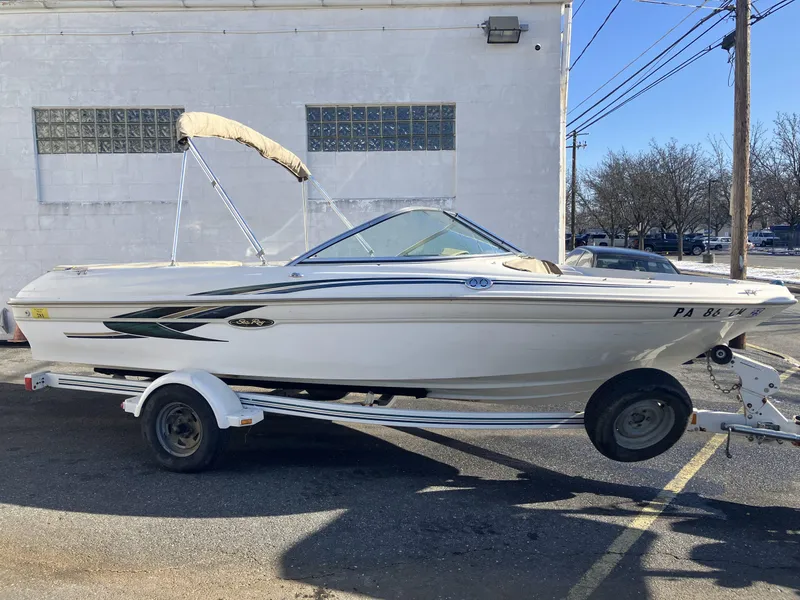 Slide: The Image of 2001 Sea Ray 180 Bow Rider boat on trailer, parked outdoors. - 0
